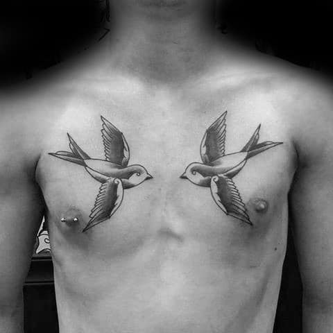 Two swallow tattoos on the chest, one on each side near the shoulders