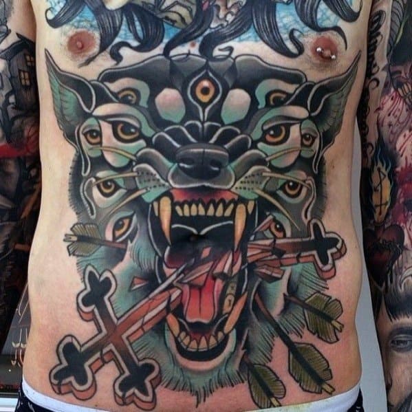 Vibrant and surreal full torso tattoo of a multi-eyed wolf with arrows and ornate crosses in its mouth, surrounded by feathers and intense details.