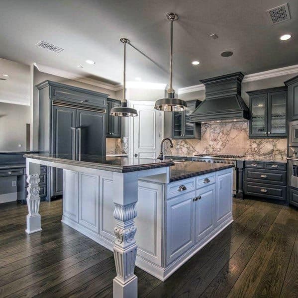 Traditional grey kitchen with a white island and marble backsplash.
