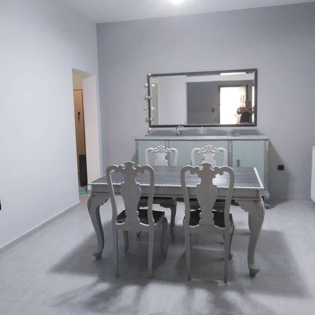 sparse dining room vintage table and chairs wall mirror