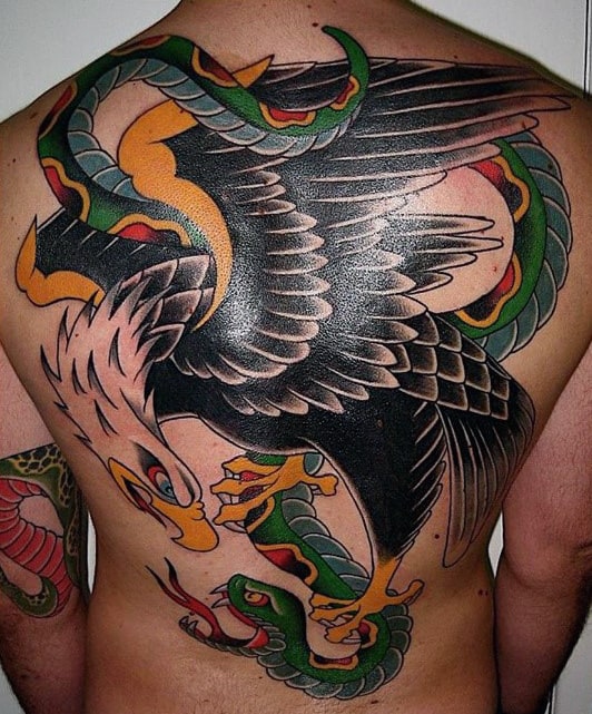 Man's back with a large tattoo of an eagle and two snakes intertwined