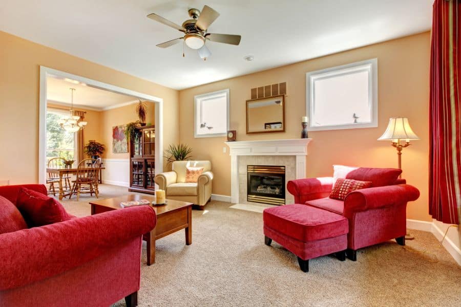 traditional family room red couches fireplace ceiling fan with light carpet