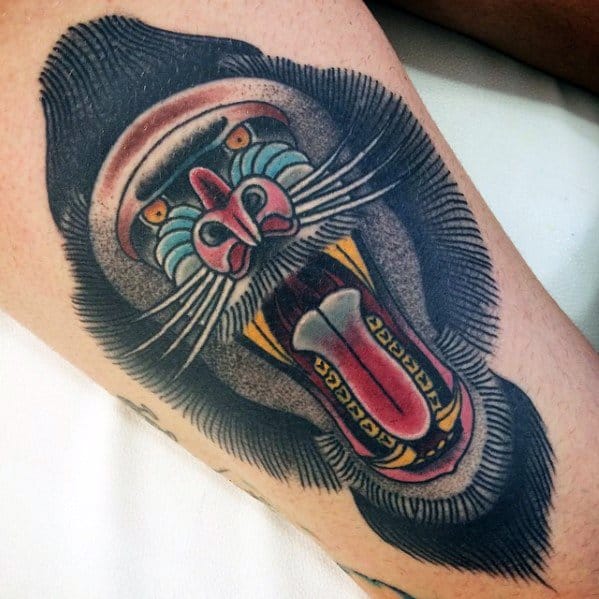 Neo-traditional baboon tattoo with bold outlines, vivid colors, and a fierce open-mouthed expression, creating a striking and dynamic leg design.