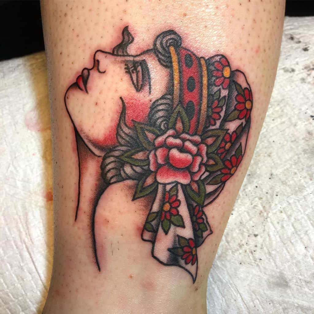 Tattoo of a woman's profile with a floral headdress on the arm, capturing a gypsy spirit