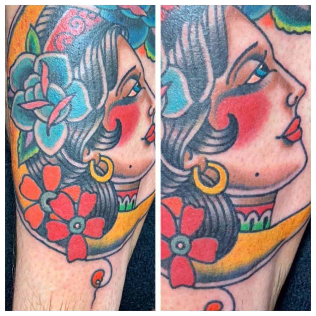 Tattoo of a colorful, vintage-style gypsy woman adorned with flowers and bold outlines