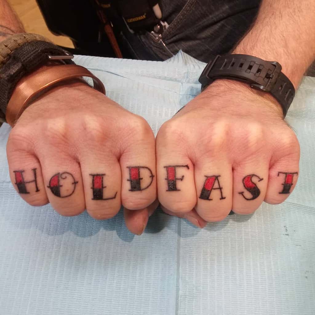 Fists with "HOLD FAST" tattoos across knuckles