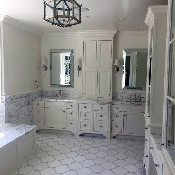 Sure! Here's your sentence without a dot at the end: "Spacious bathroom with dual sinks, hexagonal white tiles, and a chandelier