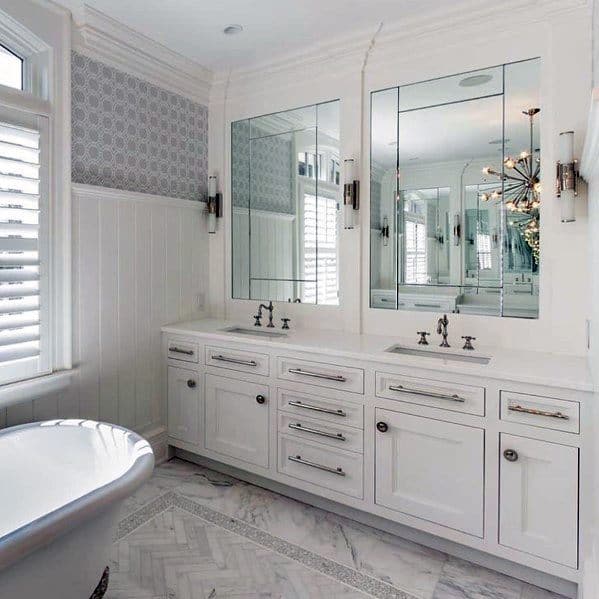 Traditional white bathroom vanity with double sinks, large mirrors, and marble floor.