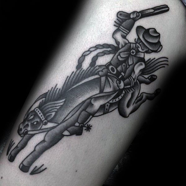 Black and grey tattoo of a cowboy on a bucking horse, holding a revolver, with bold lines and traditional shading style.