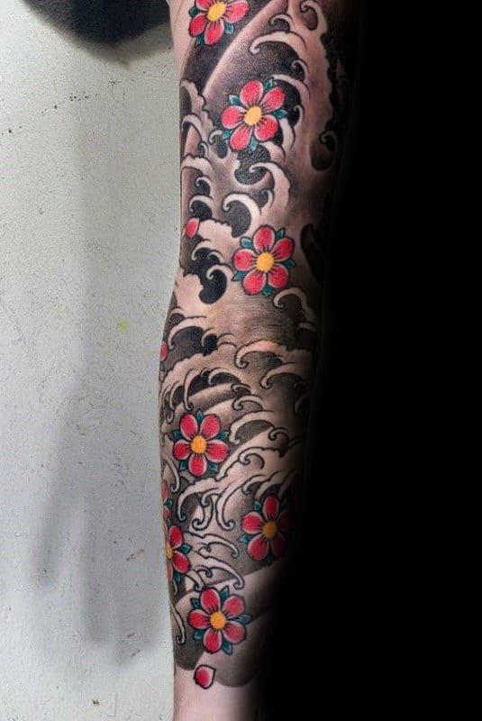 Traditional Japanese sleeve tattoo featuring vibrant cherry blossoms and bold black and grey water waves for a dynamic and artistic look