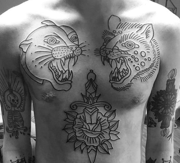 Bold chest tattoo design featuring two outlined snarling wildcats facing each other, with a dagger and rose motif placed centrally below them.