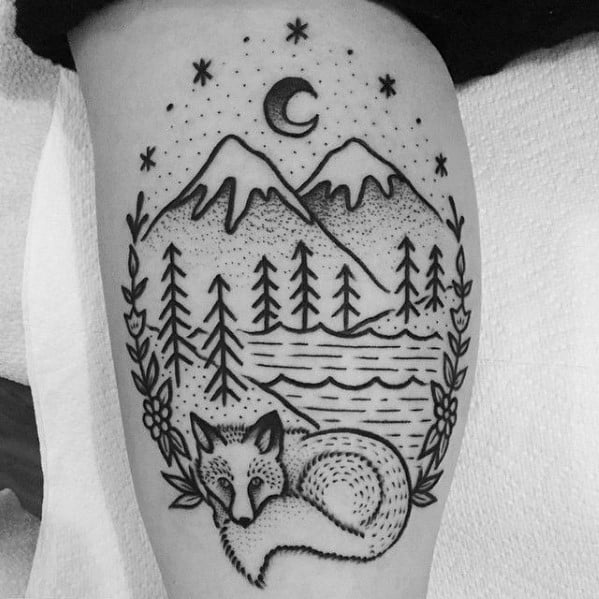 Blackwork tattoo of a sleeping fox beneath pine trees, a mountain lake, and a crescent moon with stars, framed by floral branches.