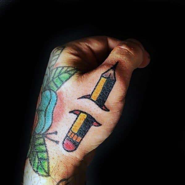 A hand tattoo featuring pencil sketches intertwined with vibrant, colorful leaves