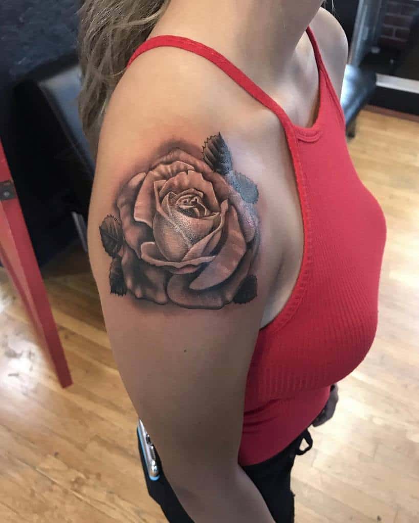 A woman with a large rose tattoo cascading from her shoulder