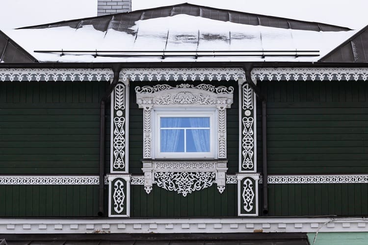 traditional russian wooden ornate exterior window trim green wall