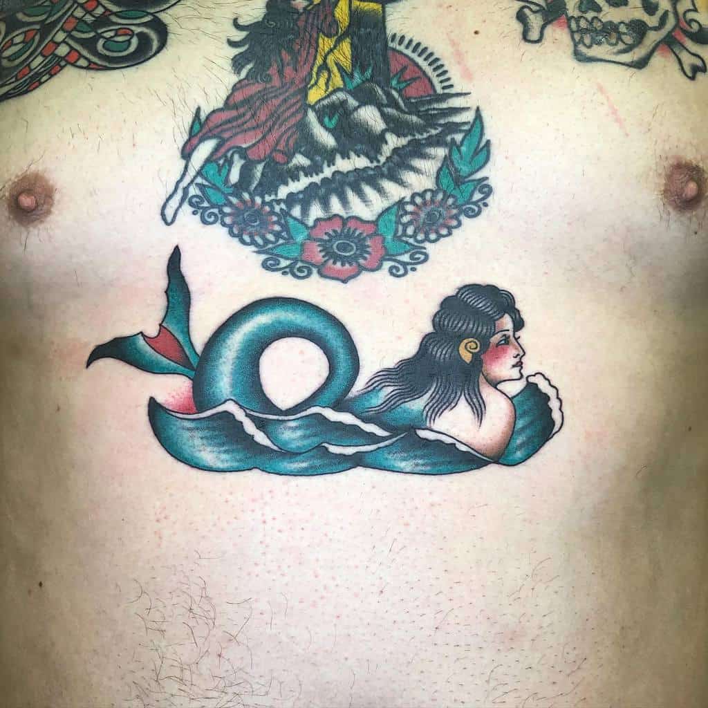 Classic traditional tattoo of a siren with a curled tail, emerging from stylized ocean waves, featuring bold outlines and vintage-inspired colors