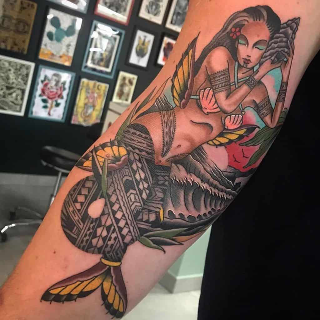Traditional tattoo of a serene mermaid holding a conch shell, adorned with intricate Polynesian-inspired patterns, vibrant colors, and oceanic elements