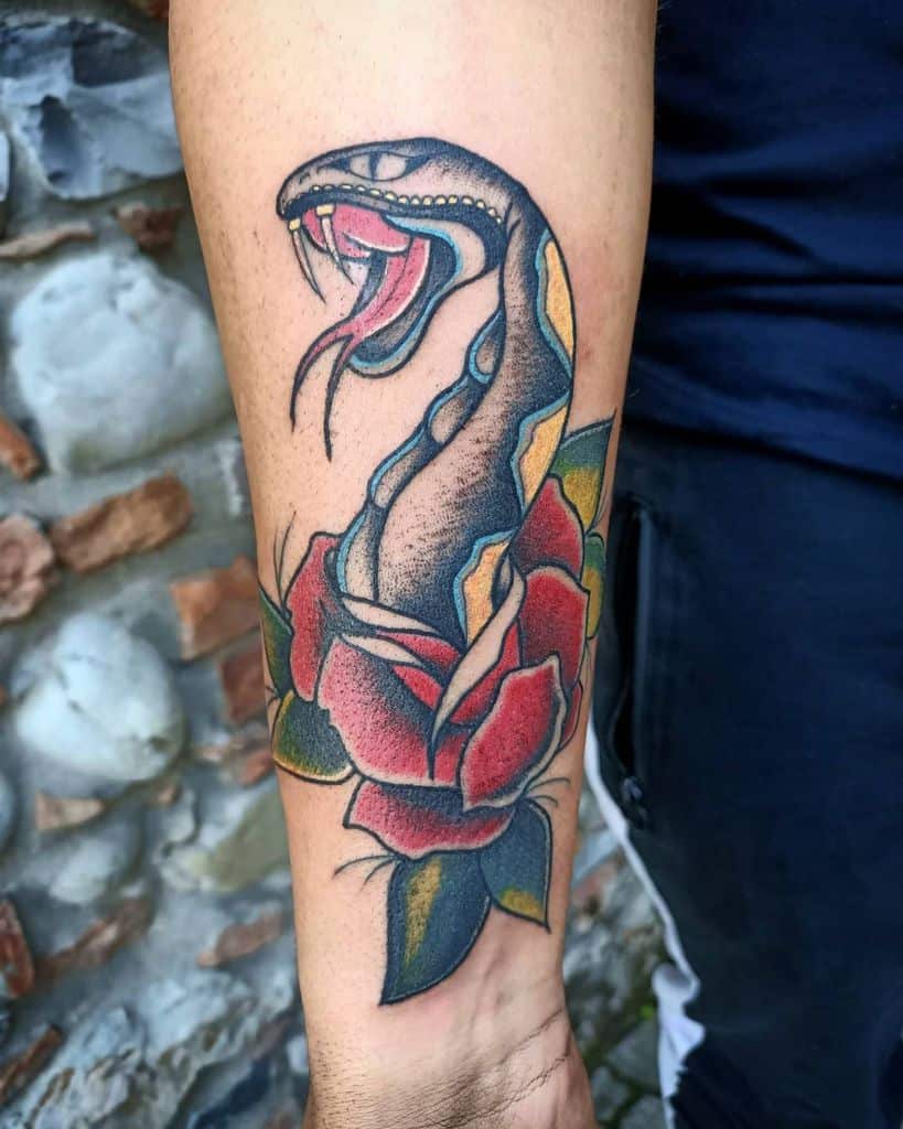 A tattoo of a snake entwined with a red rose on a forearm