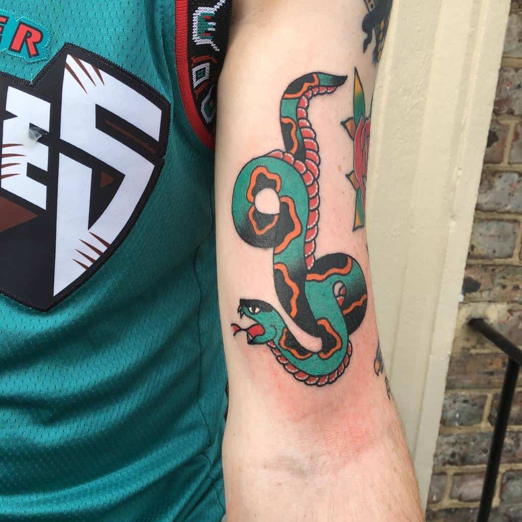 Tattoo of a green and orange snake on an arm
