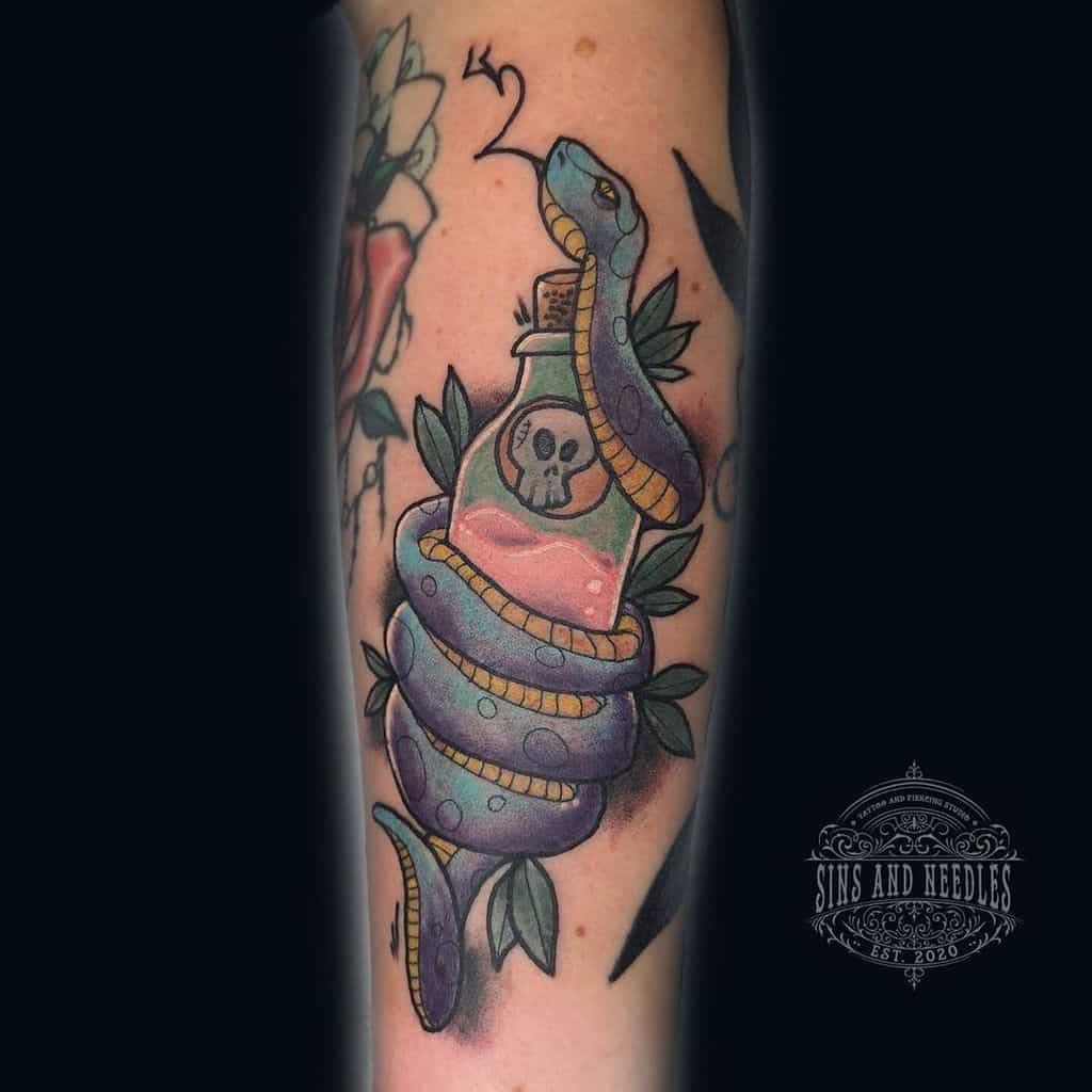 Tattoo of a snake coiled around a bottle with a skull design, surrounded by leaves