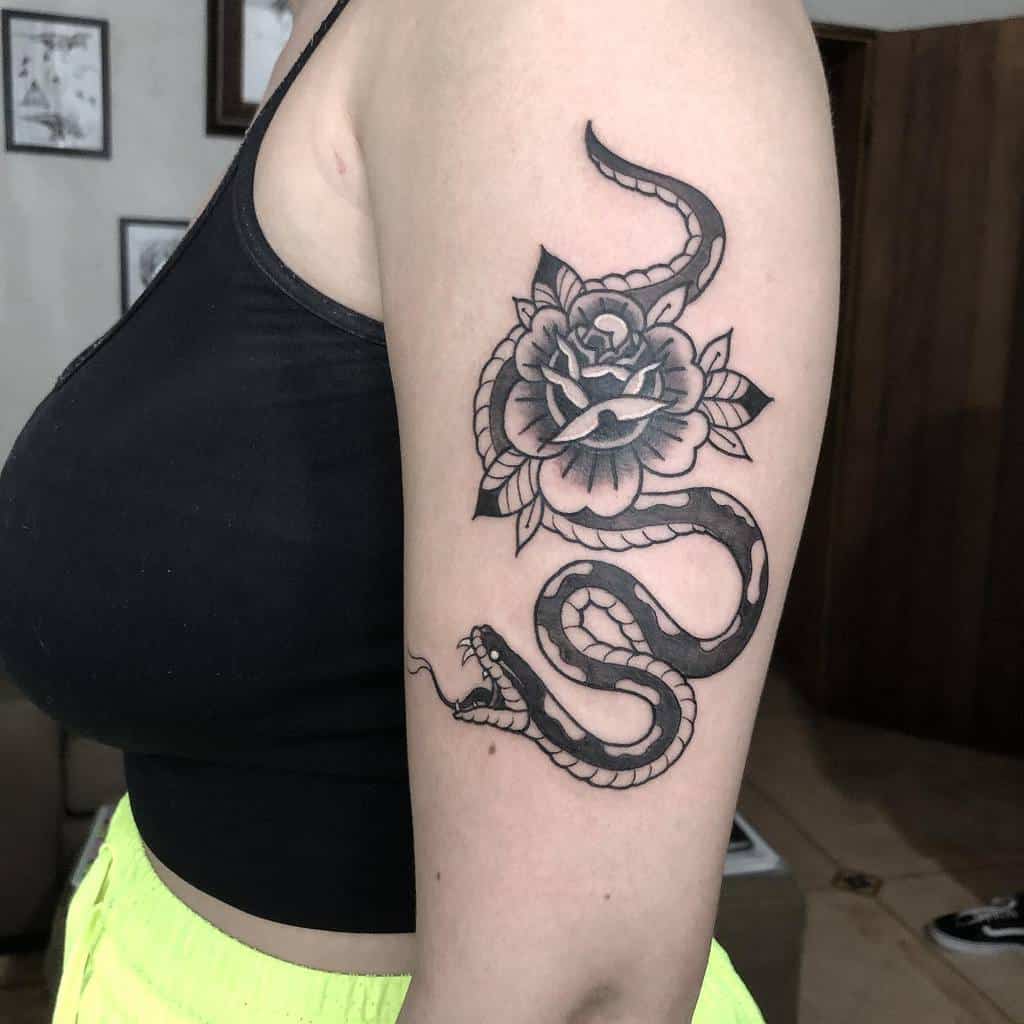 Arm with a tattoo of a snake coiled around a rose