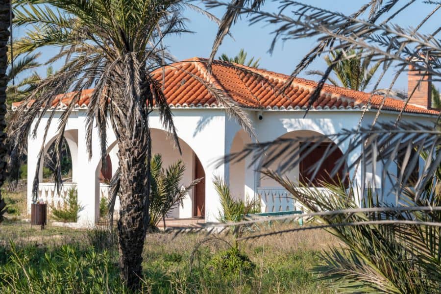 white traditional spanish-style with terra cotta tile roof