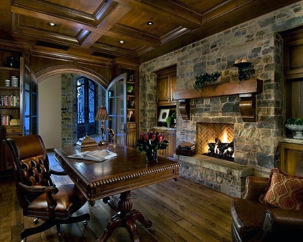 Elegant study with a traditional stone fireplace, wooden built-in shelves, and a coffered ceiling, creating a warm, classic atmosphere.