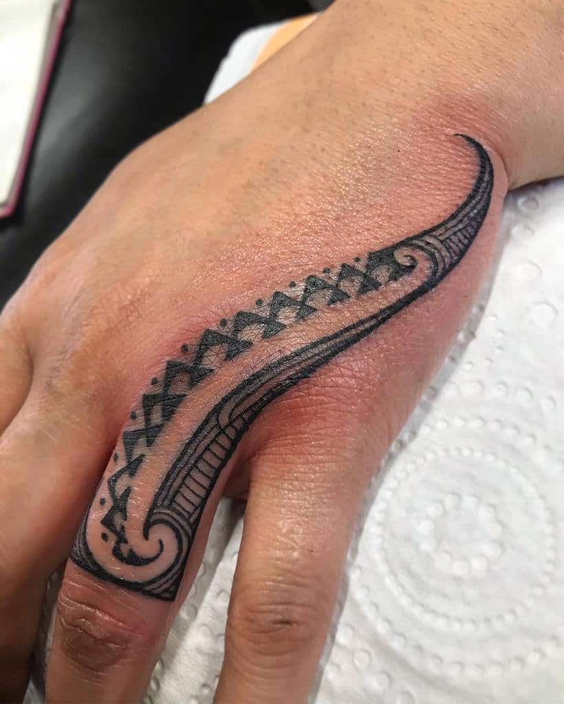 Bold, intricate wedding ring tattoo featuring tribal patterns and curves with artistic detailing