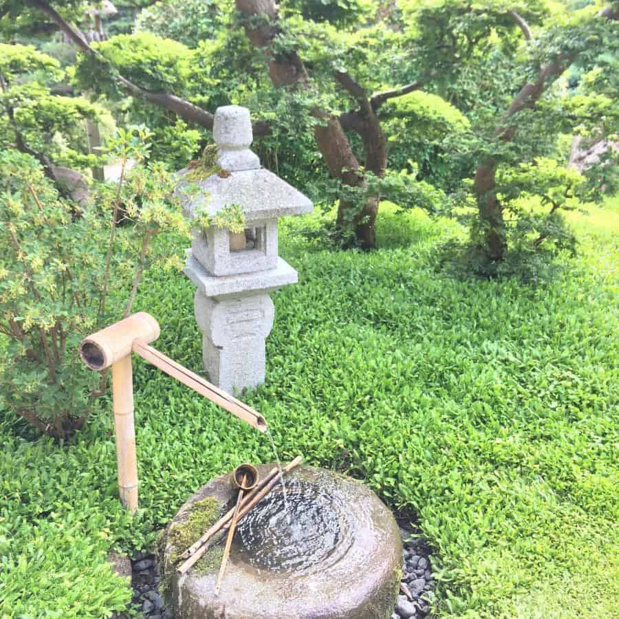 traditional zen garden with water feature and stone temple sculpture