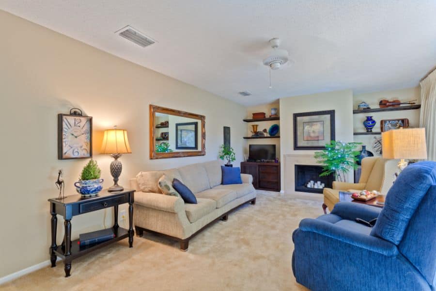 modern family room blue accent chair wall shelves wall mirror