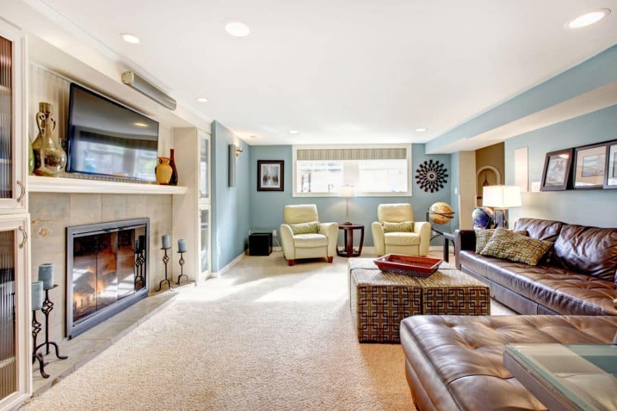 blue wall living room brown leather couch fireplace carpet 