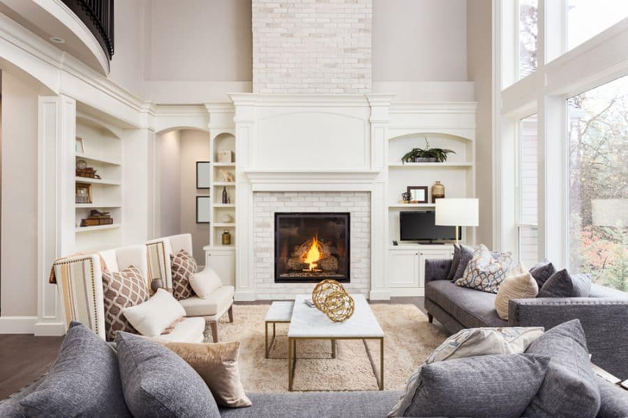 white family room fireplace gray couch marble topped table 