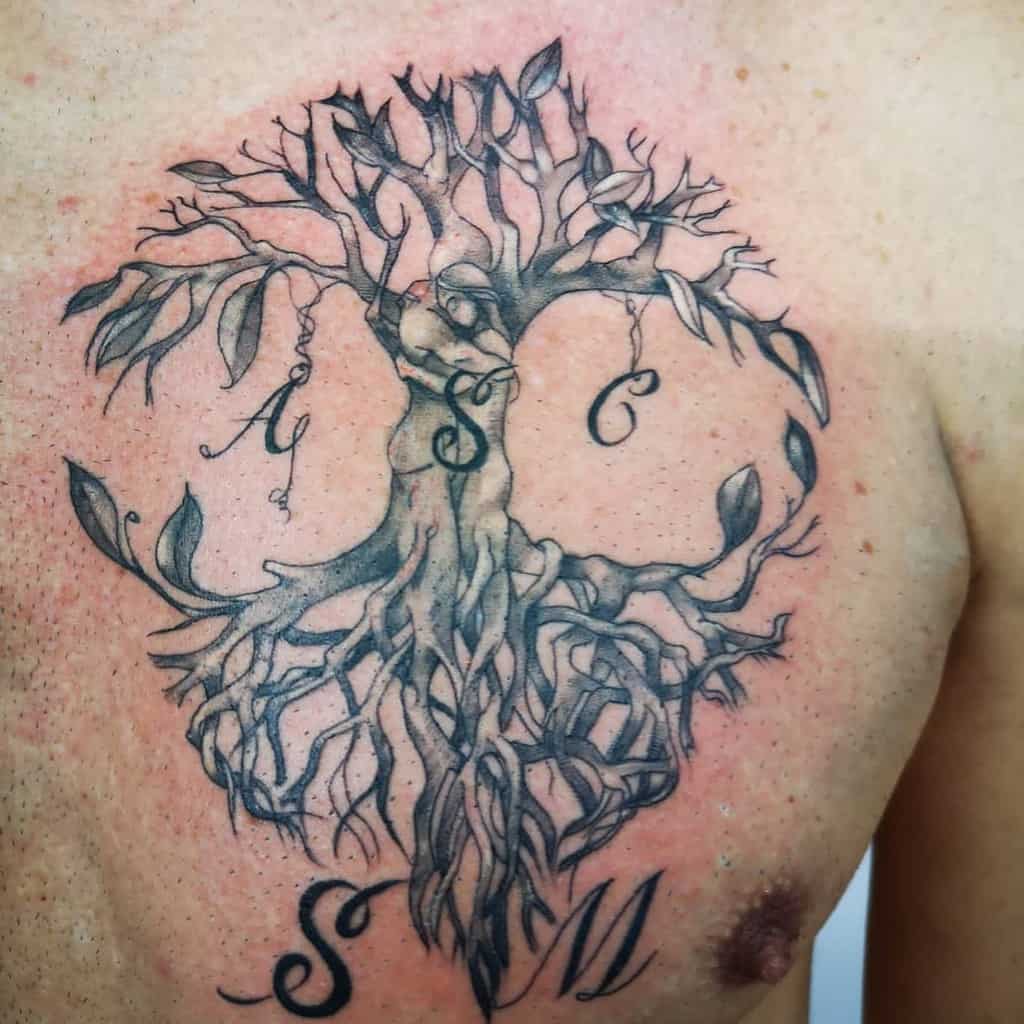 Intricate chest tattoo of a tree of life, featuring flowing roots and branches intertwined with initials, symbolizing personal connections