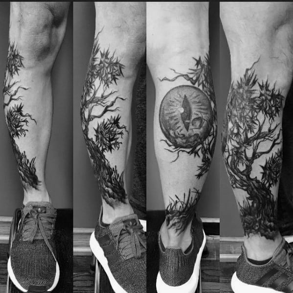 Black ink tree tattoo wrapping around the leg, featuring a twisted trunk, dense branches, and a circular moon design with a wolf silhouette.