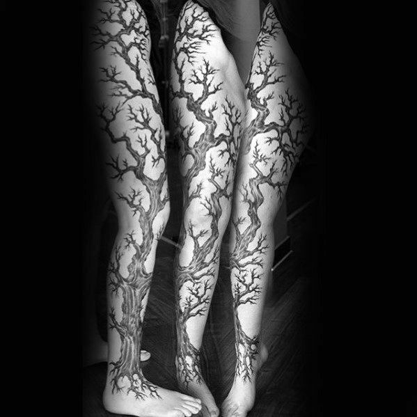 Black ink full-leg tree tattoo, featuring intricate twisting branches and roots extending from the foot to the thigh for a bold, nature-inspired design.