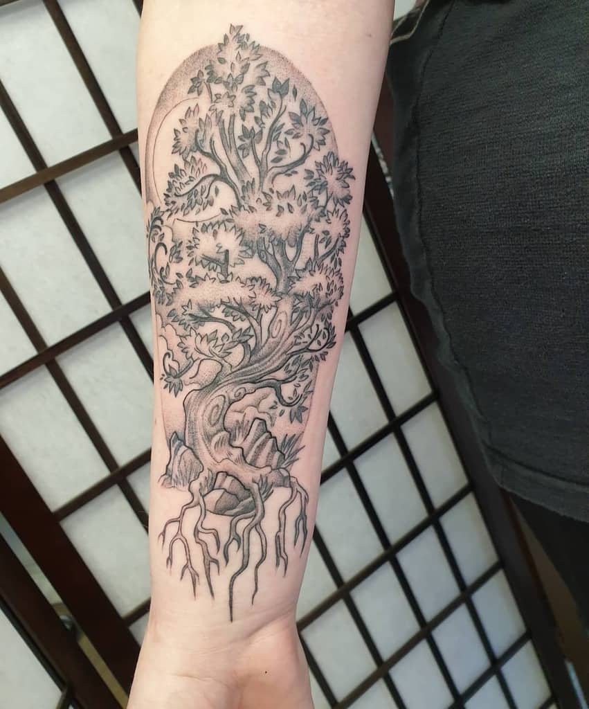 The tattoo features Yggdrasil with intricate branches and roots, enclosed in an arched frame, symbolizing connection, wisdom, and Norse mythology.