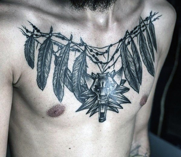 Detailed chest tattoo of feathers and a snarling wolf head