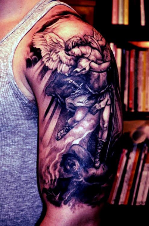 Arm with a detailed tattoo of an angel and a demon in a battle scene