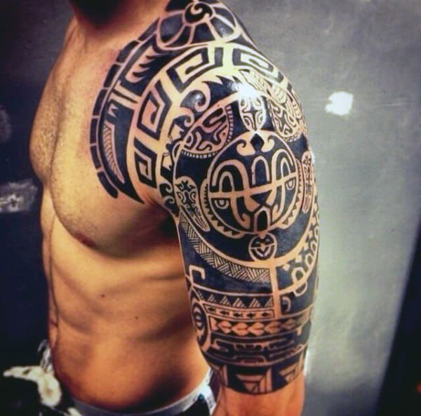 Man with detailed tribal tattoo covering shoulder and upper arm