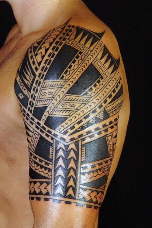 Intricate tribal tattoo covering a man's shoulder and upper arm