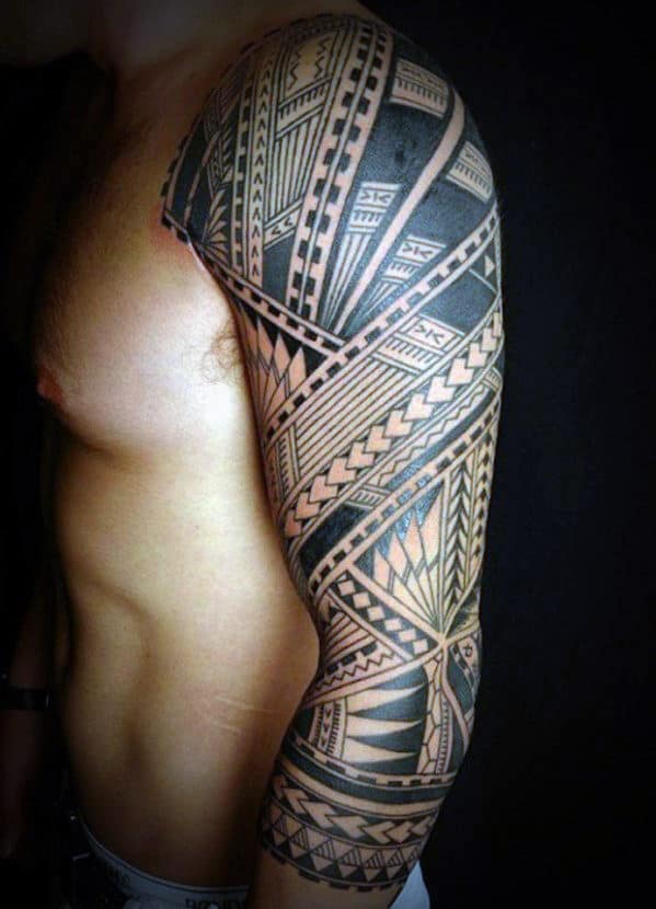 Person with a detailed, geometric tribal tattoo sleeve on their upper arm and shoulder