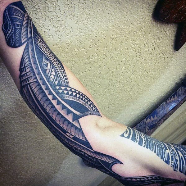Polynesian shark tattoo sleeve on arm with bold geometric patterns and flowing lines symbolizing strength, protection, and oceanic spirit.