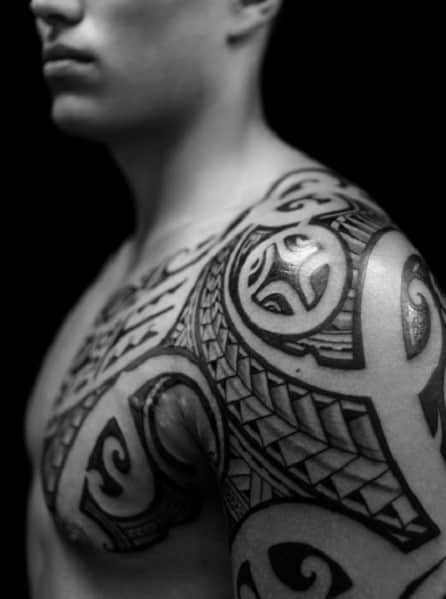 Person with intricate tribal tattoos on their shoulder and chest