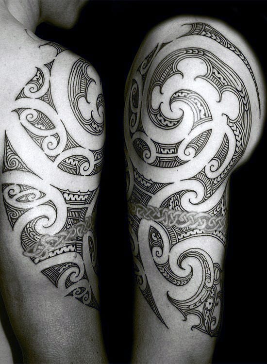 Intricate tribal-style tattoo on a person's shoulder and upper arm