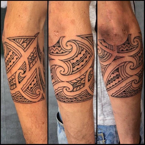 Forearm with a detailed black tribal-style tattoo design