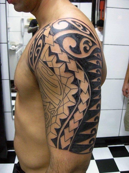 Man with a black tribal tattoo covering his shoulder and upper arm
