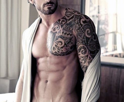 Man with tribal tattoos on his shoulder and arm