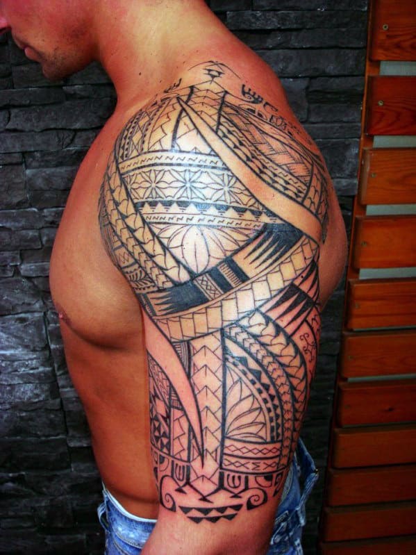 A man with an intricate tribal tattoo covering his shoulder and upper arm