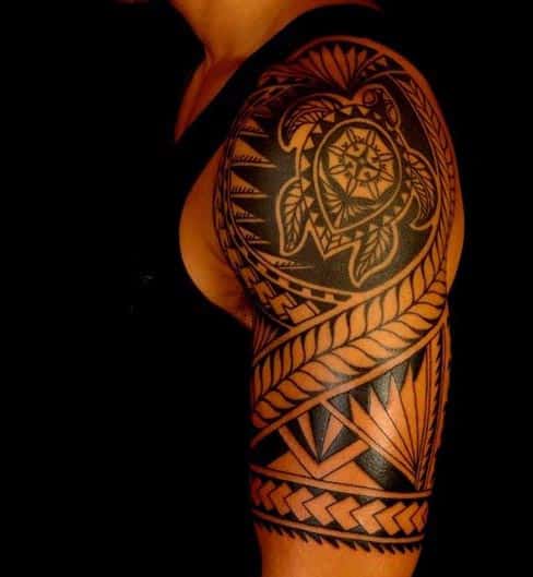 Arm tattoo featuring a tribal design with a turtle motif