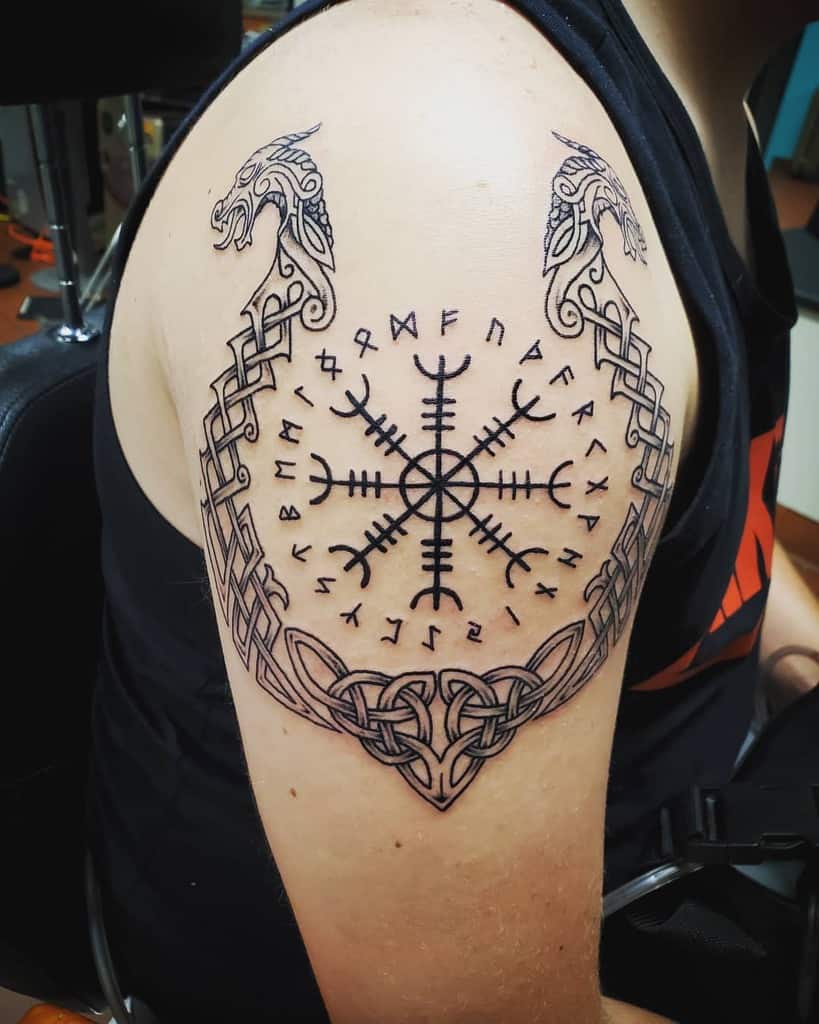 Arm tattoo with Viking-inspired design, featuring intertwined dragons and runic symbols